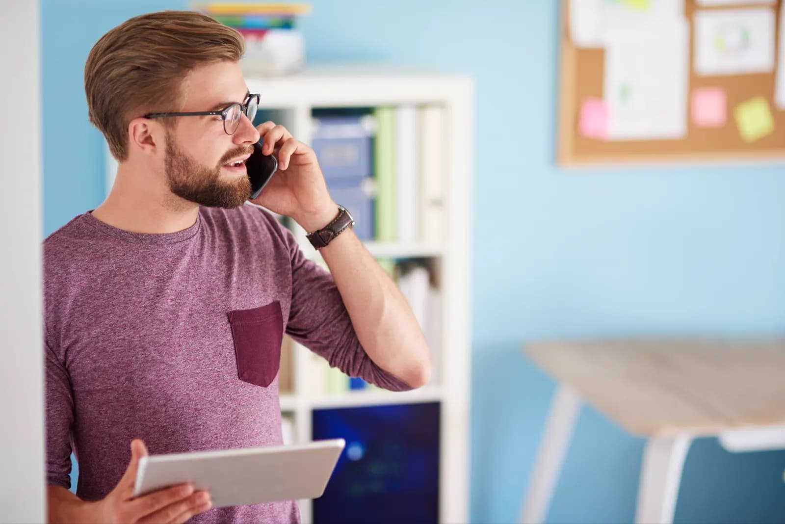 Home service business owner taking a customer call while holding a tablet.